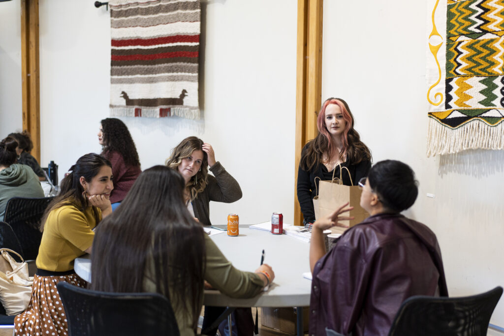 YPP participants and a facilitator discuss their policy asks with each other around a table.